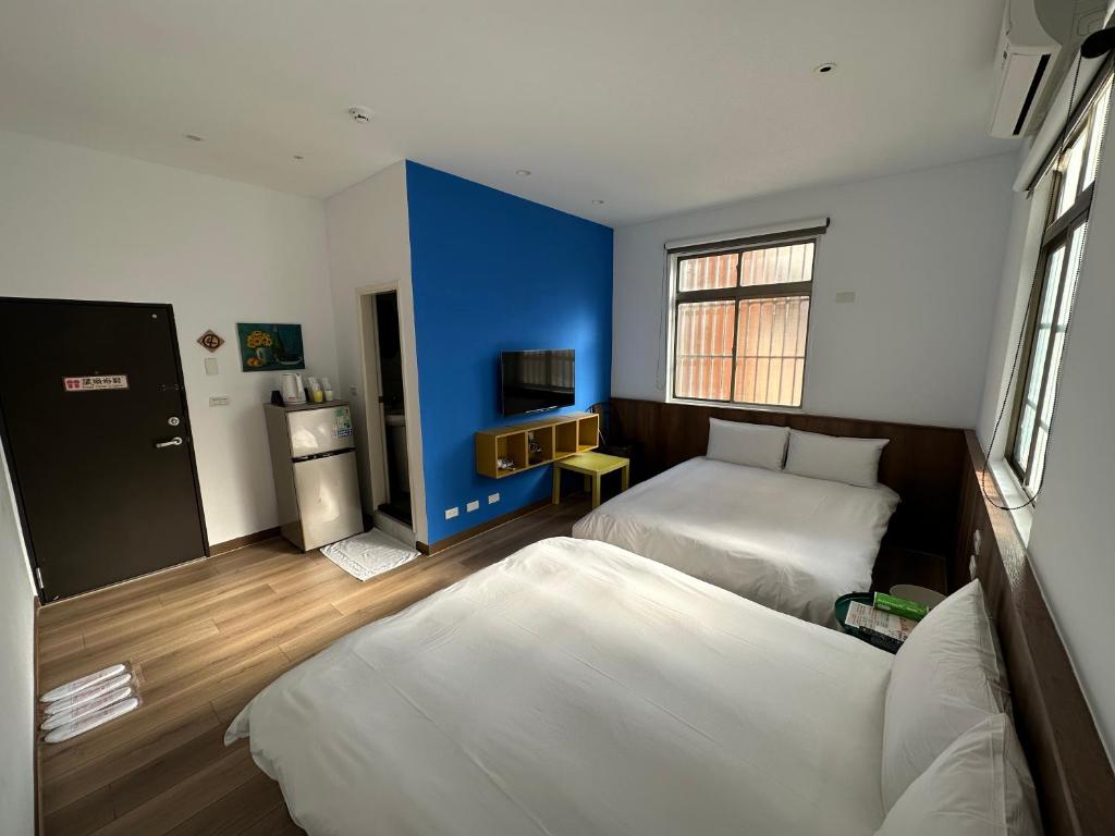 1 dormitorio con 2 camas y pared azul en 逢甲憶廊, en Taichung