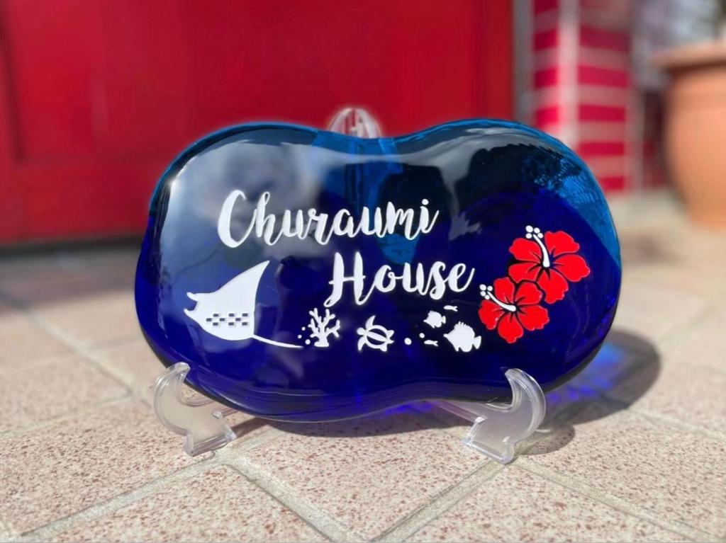 ein blauer Behälter mit den Worten Quantenhaus drauf in der Unterkunft Churaumi House in Motobu