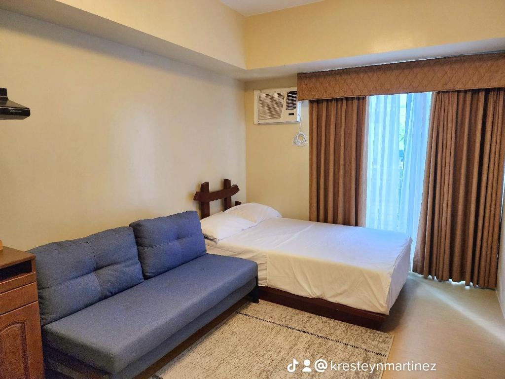 a hotel room with a bed and a couch at AVIDA TOWER Free Airport Pick up for 3 nights stay or more in Davao City