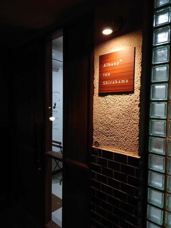 a sign on a brick wall with a sign on it at Albany inn Shirahama アルバニーイン白浜 in Shirahama