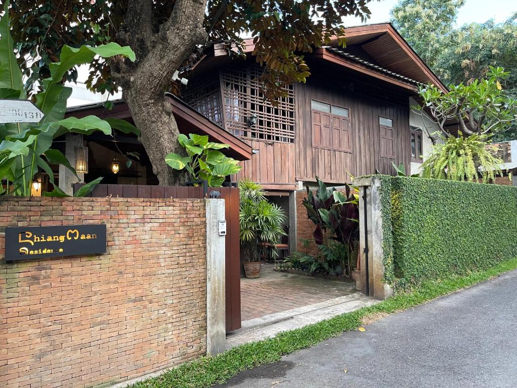 a brick wall with a gate in front of a house at Chiang Maan Residence in Chiang Mai
