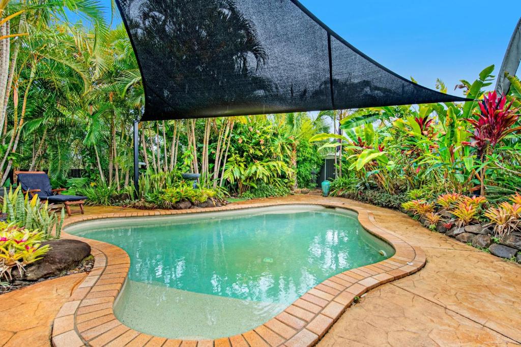 a swimming pool in the middle of a garden at A Family Home Away From Home in Gold Coast