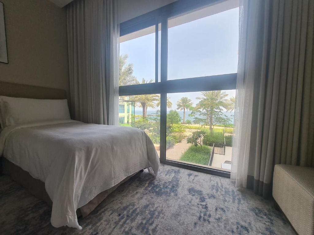 a bedroom with a bed and a large window at Luxury sea view Apartment In Address Hotel Fujairah in Fujairah