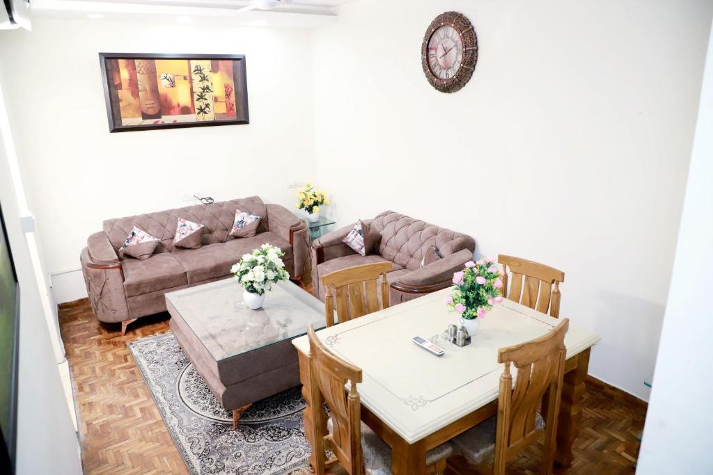 - un salon avec un canapé, une table et des chaises dans l'établissement Fortune Home Service Apartment 3Bhk,E-28 Saket 1B, à New Delhi