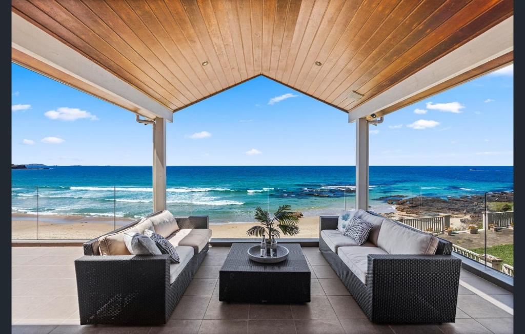 a living room with a view of the ocean at Sea View - Absolute Beachfront Shellharbour in Shellharbour