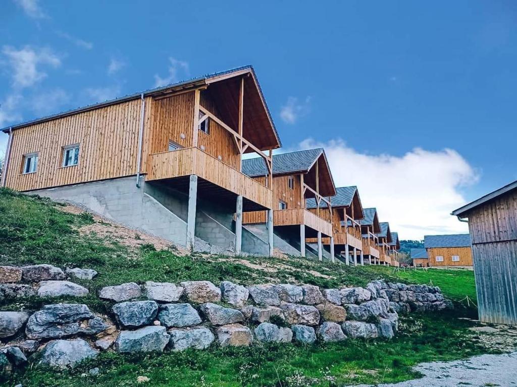 a row of wooden buildings on top of a hill at Gites Jura Sud in Charchilla