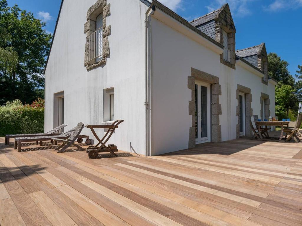 une terrasse en bois avec deux chaises et un bâtiment dans l'établissement Grande Villa à Carnac - 12 pers, Jardin 2000m², Wifi, Plage à Proximité - FR-1-477-19, à Carnac