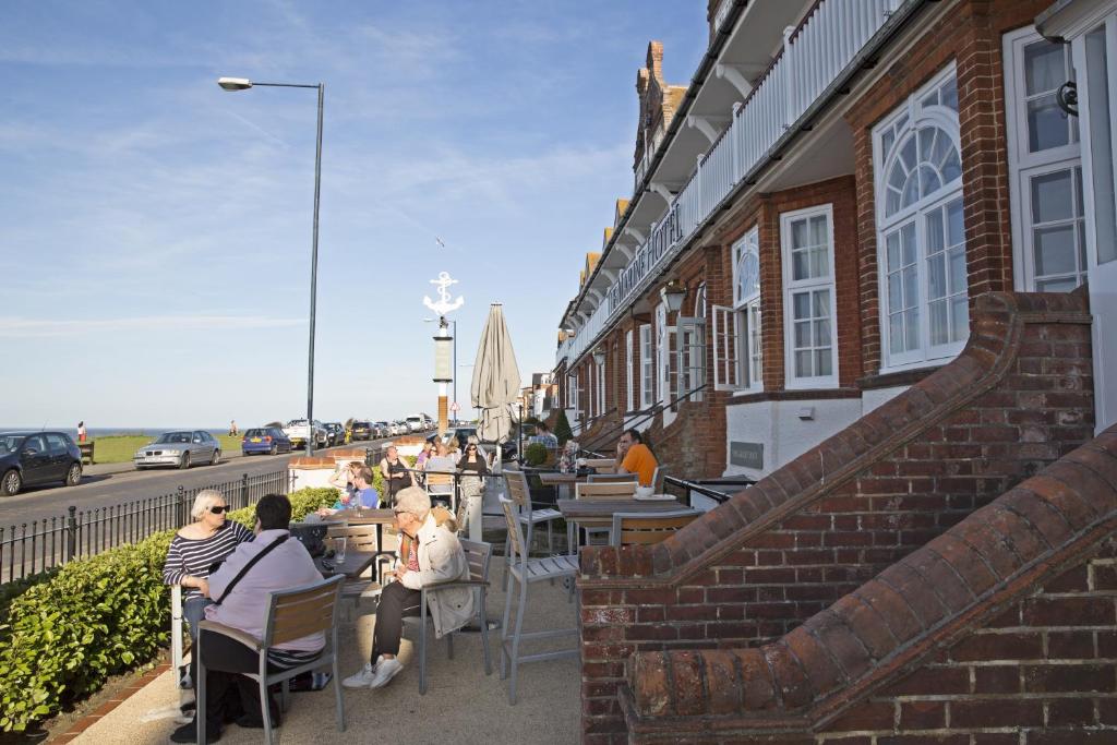 a group of people sitting at tables outside a building at The Marine in Whitstable
