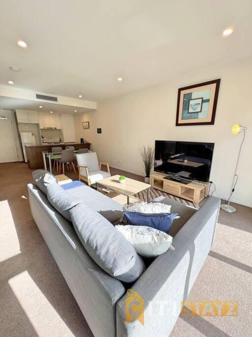 a living room with a couch with pillows on it at Bright in Braddon! 1 bd 1bth Apt in Canberra