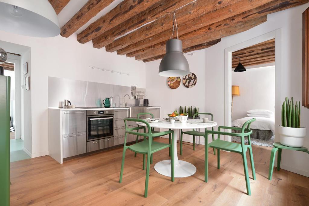 kuchnia ze stołem i zielonymi krzesłami w obiekcie Venice Parsley w Wenecji