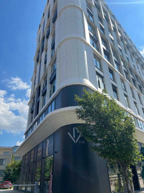 a building with a tree in front of it at Green Eyes Apartments in Sofia