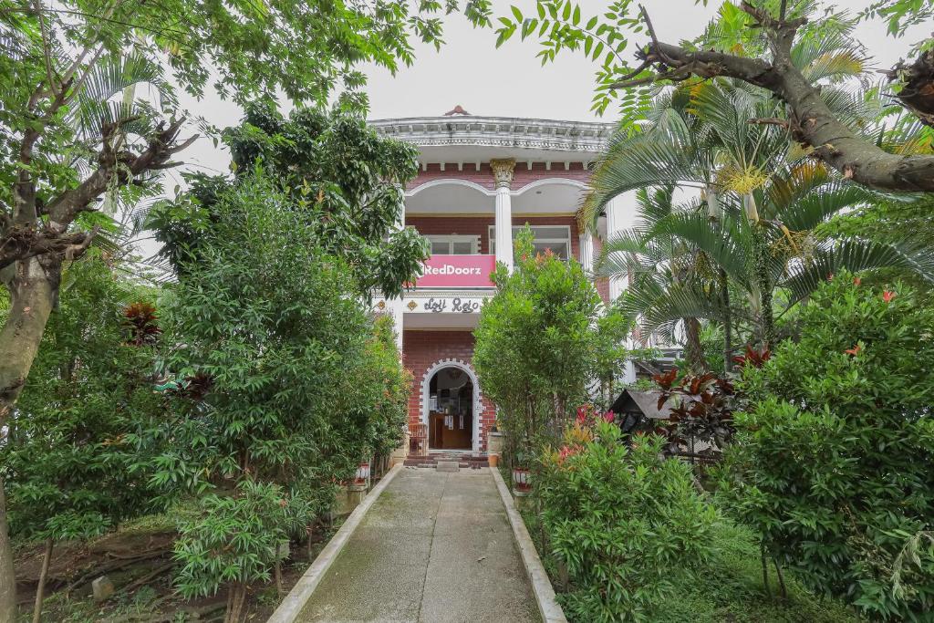 a large building with trees in front of it at RedDoorz at Villa Puncak Tidar in Malang
