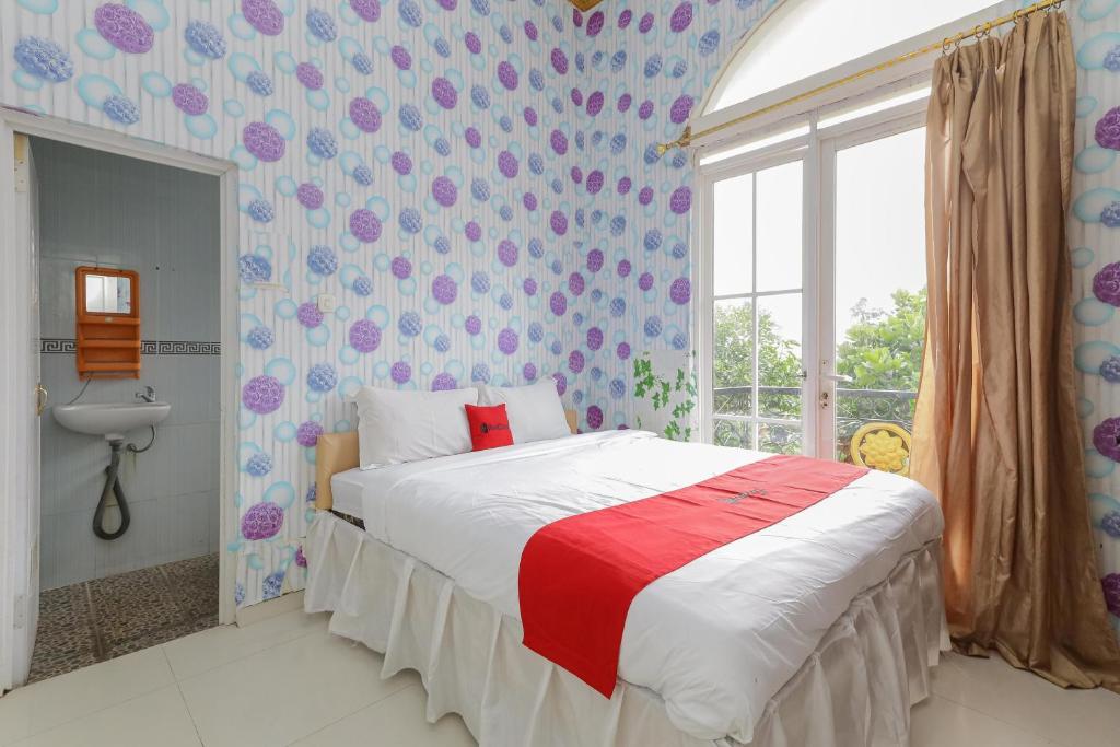Postel nebo postele na pokoji v ubytování RedDoorz at Villa Puncak Tidar