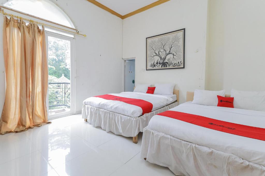 Postel nebo postele na pokoji v ubytování RedDoorz at Villa Puncak Tidar
