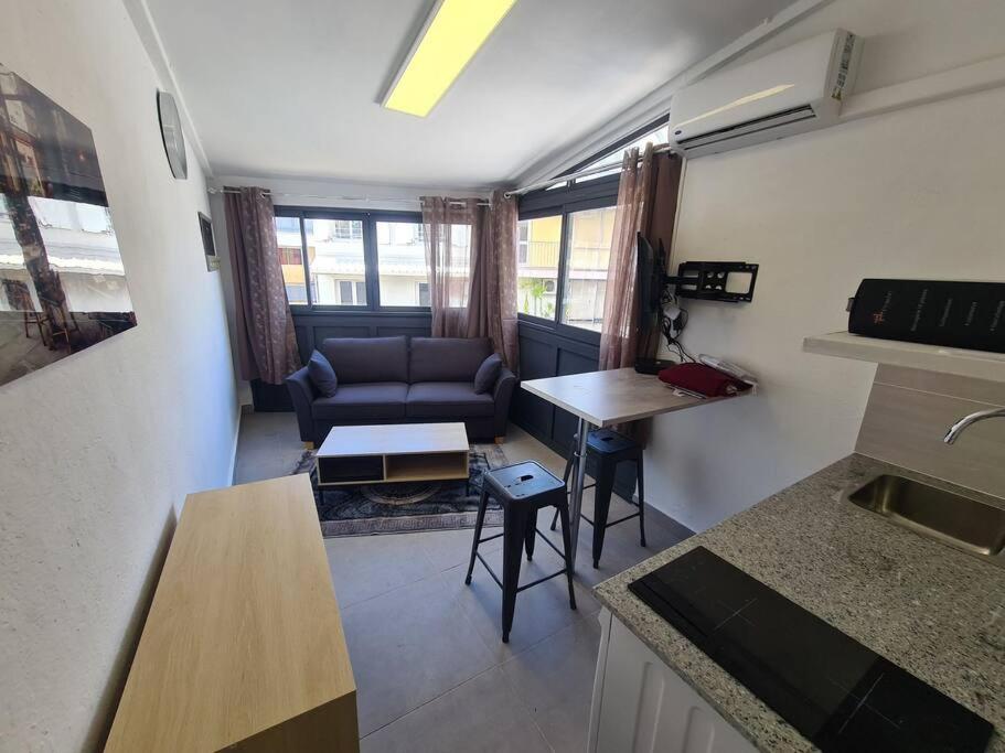 een woonkamer met een bank en een tafel bij Beau Studio Hypercentre Saint Denis in Saint-Denis
