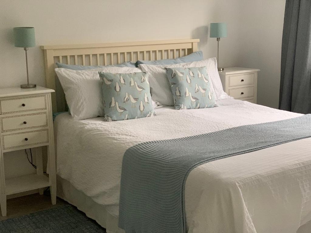 a bedroom with a white bed with two night stands at Seaglass Cottage, 5 mins from beach, leafy lane, hot tub in South Hayling