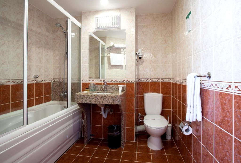 a bathroom with a toilet and a sink and a tub at SEFA HOTEL 1 ÇORLU in Corlu