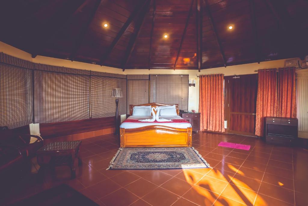 a bedroom with a bed and a chair in it at Malpe Sea Front Cottages in Udupi