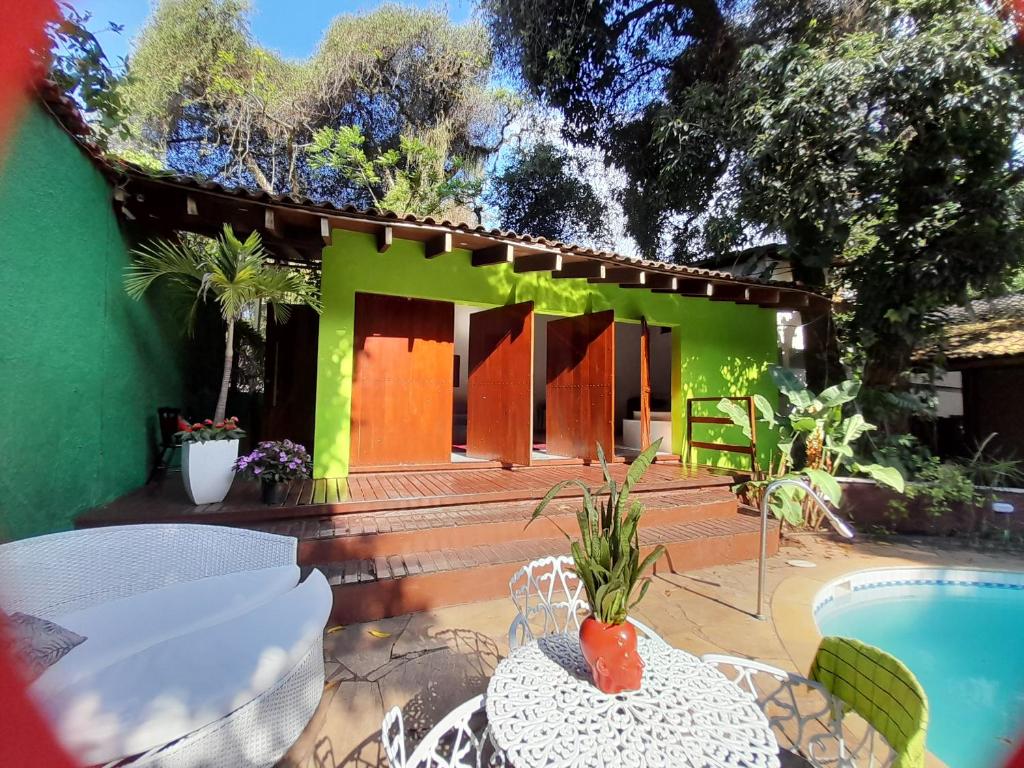een groen huis met een zwembad en een tafel en stoelen bij Pousada Solar do Redentor in Rio de Janeiro