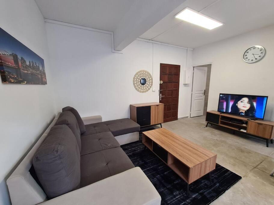 a living room with a couch and a tv at T-3 Hypercentre Saint Denis Rue Piétonne in Saint-Denis