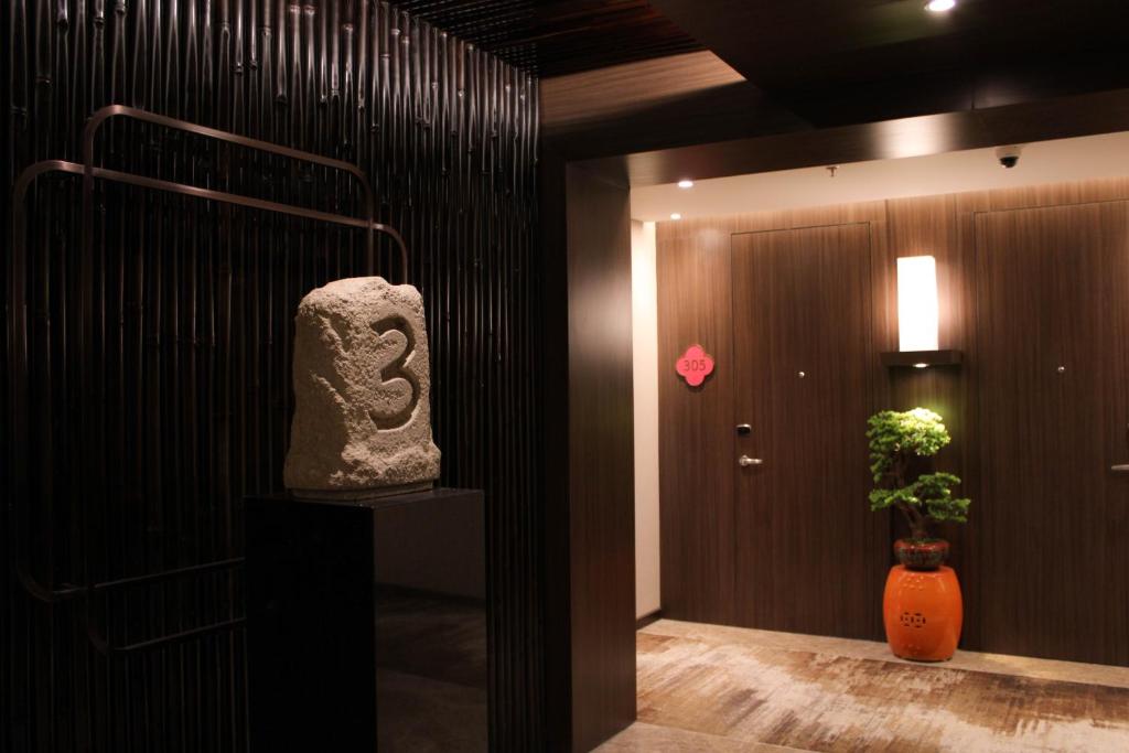 a room with a statue and a door with a plant at Ashley Tang Menteng Jakarta in Jakarta