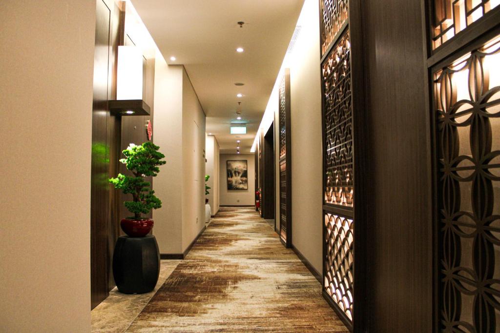 a hallway of a hotel with a potted plant at Ashley Tang Menteng Jakarta in Jakarta