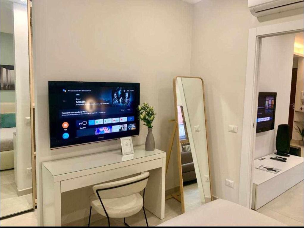 ein Wohnzimmer mit einem Schreibtisch und einem TV darauf in der Unterkunft Le Suite Abitare Roma in Rom