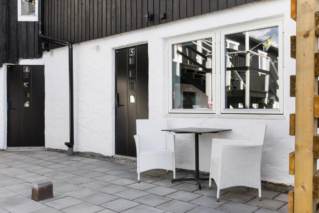 une table et des chaises installées à côté d'un bâtiment dans l'établissement Åreskutan Huså lägenhet 5, à Huså