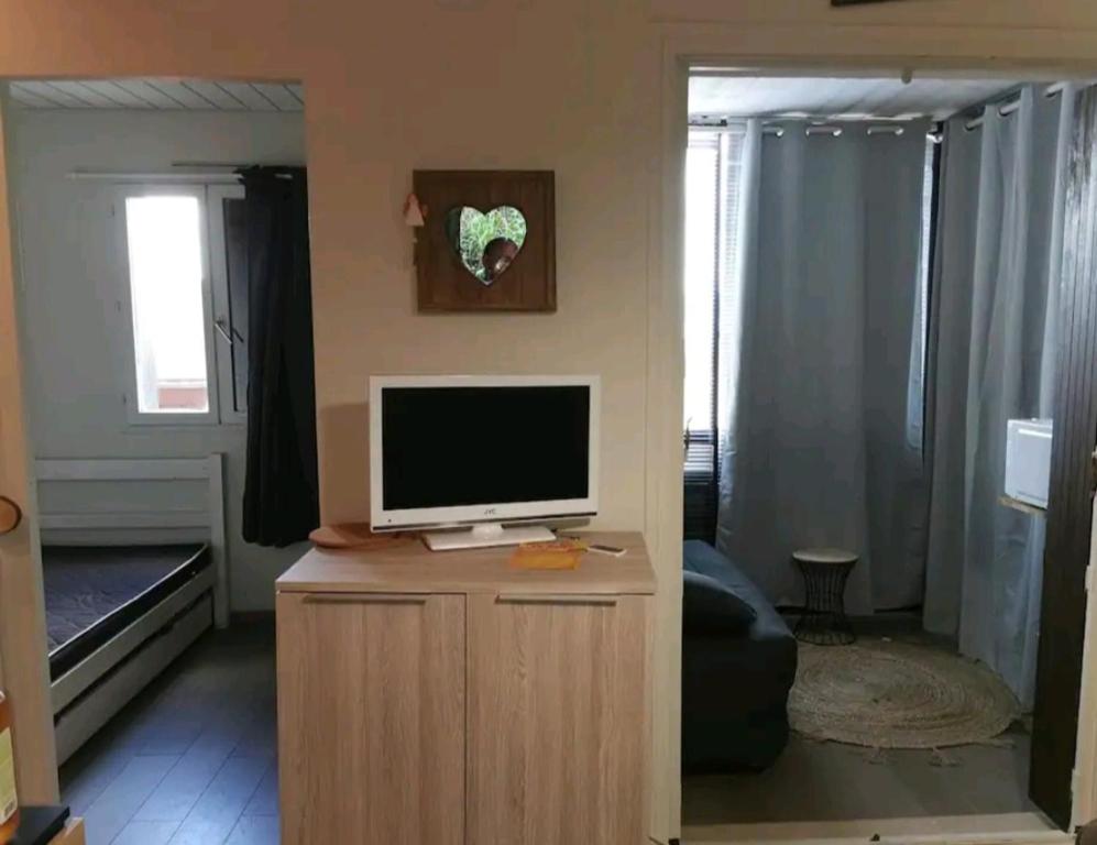 een woonkamer met een televisie op een houten kast bij Coquet appartement in Bolquere Pyrenees 2000