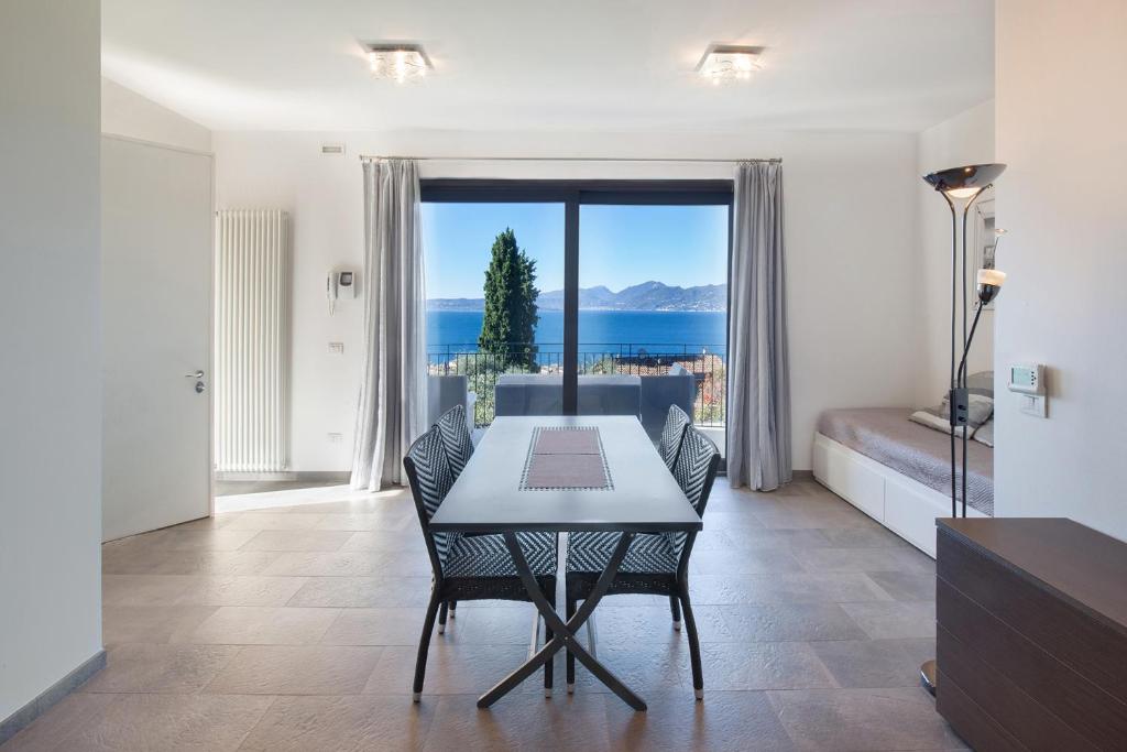 a dining room with a table and a view of the ocean at Villa Loncrino, First Floor Apartment in Torri del Benaco