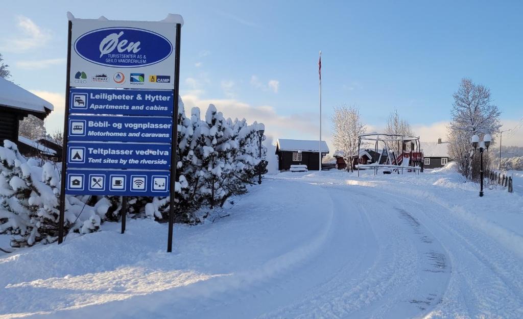 a sign in the snow next to a road at Øen Turistsenter Apartments in Geilo