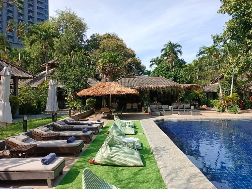 un resort con sedie a sdraio e piscina di Let's Hyde Pattaya Resort & Villas - Pool Cabanas a Pattaya North