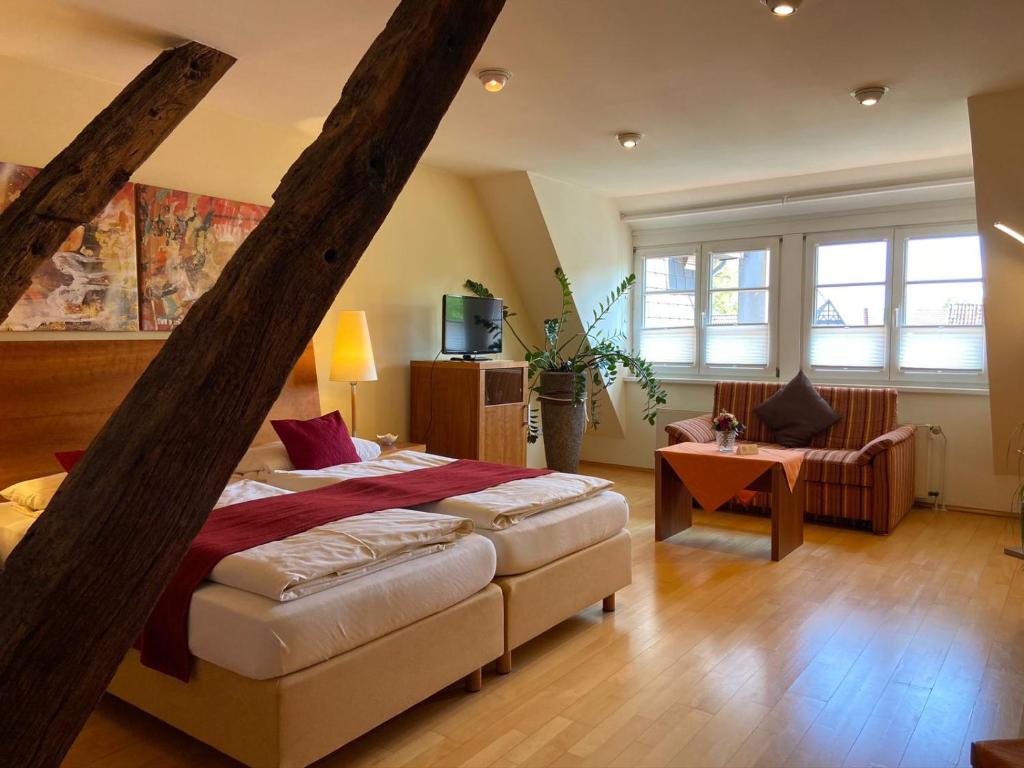 ein Schlafzimmer mit einem Bett und einem Stuhl in einem Zimmer in der Unterkunft Hotel Pilgrimhaus in Soest