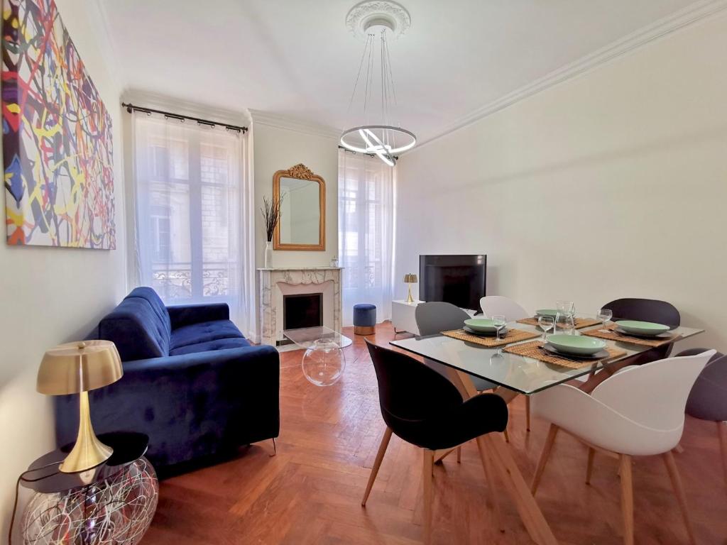 sala de estar con sofá azul y mesa en Le LORRAINE, en Niza
