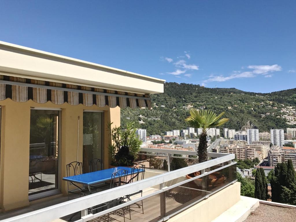 une maison avec une table bleue sur le balcon dans l'établissement Appartement 'Eucalyptus', à Nice