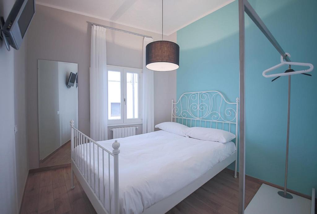 a bedroom with a bed with a blue headboard at Apartments Florence - Pinzochere White in Florence