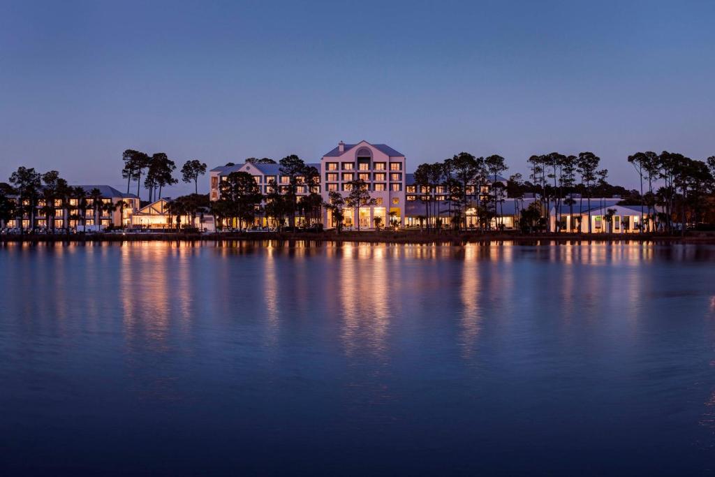 a large building on the shore of a lake at night at Bluegreen's Bayside Resort and Spa at Panama City Beach in Panama City Beach
