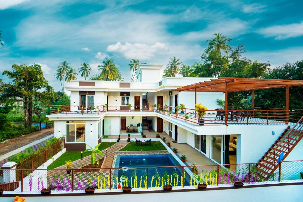 a house with a swimming pool and a balcony at CanvaSand By Eease Hospitality in Nagaon