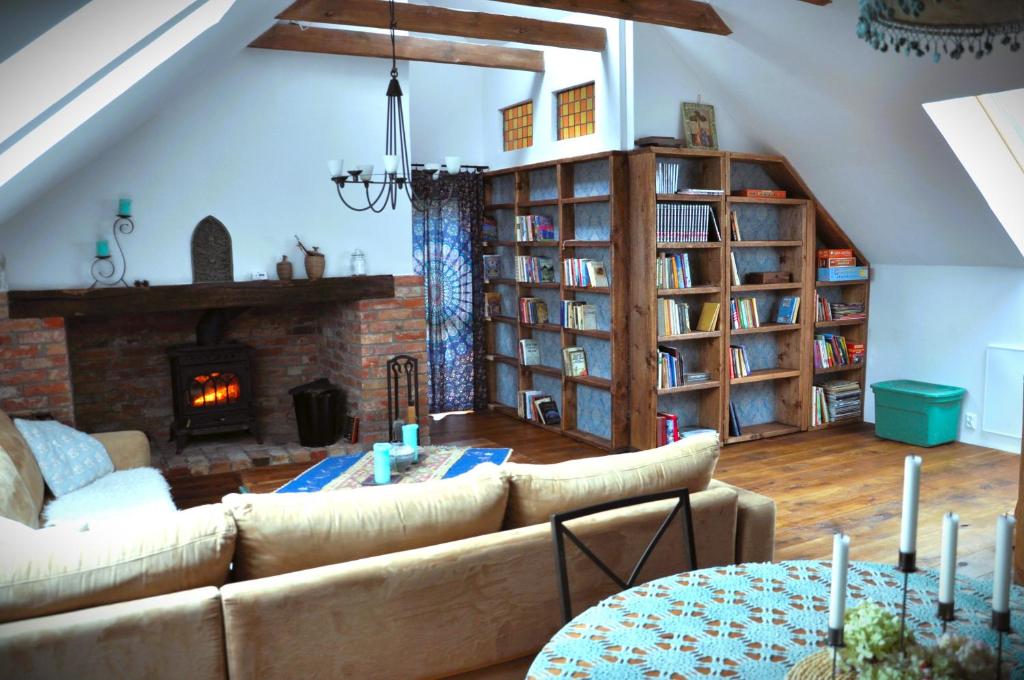 een woonkamer met een bank en een open haard bij Forreset - leśny apartament, sauna i balia jacuzzi in Gietrzwałd