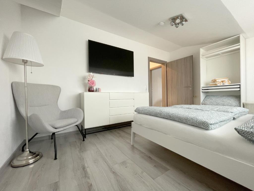 um quarto com uma cama, uma secretária e uma cadeira em F10 APARTMENT Illertissen SKY em Illertissen
