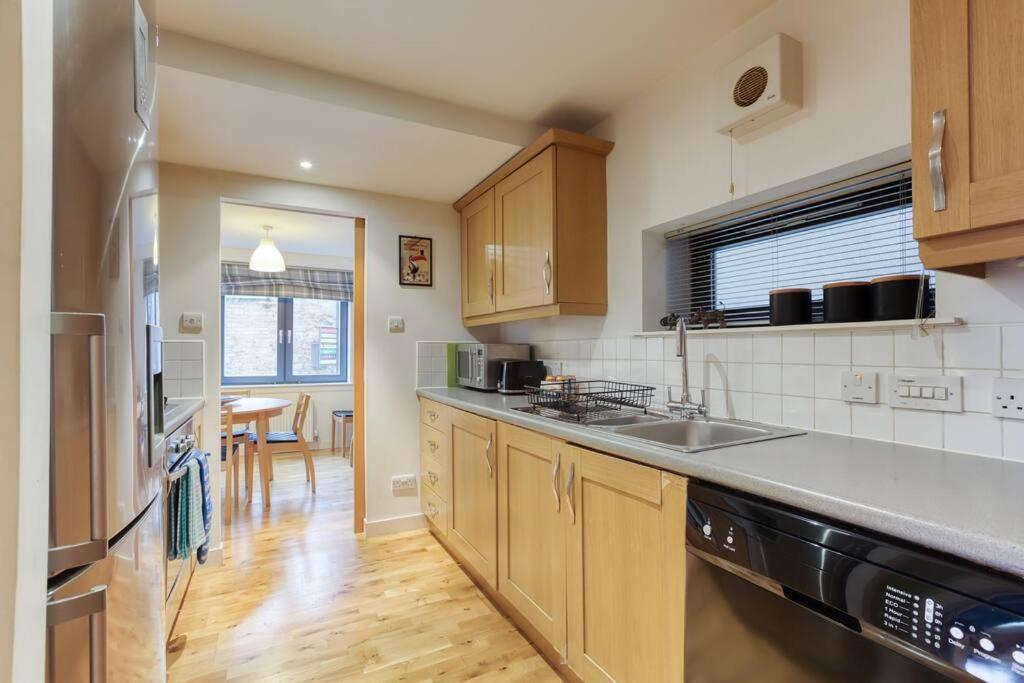 a kitchen with a sink and a counter top at *Amazing Location!*In heart of the City. 2BR & Cot in Edinburgh