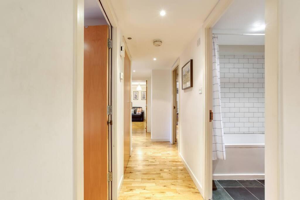 a hallway with white walls and a wooden floor at *Amazing Location!*In heart of the City. 2BR & Cot in Edinburgh