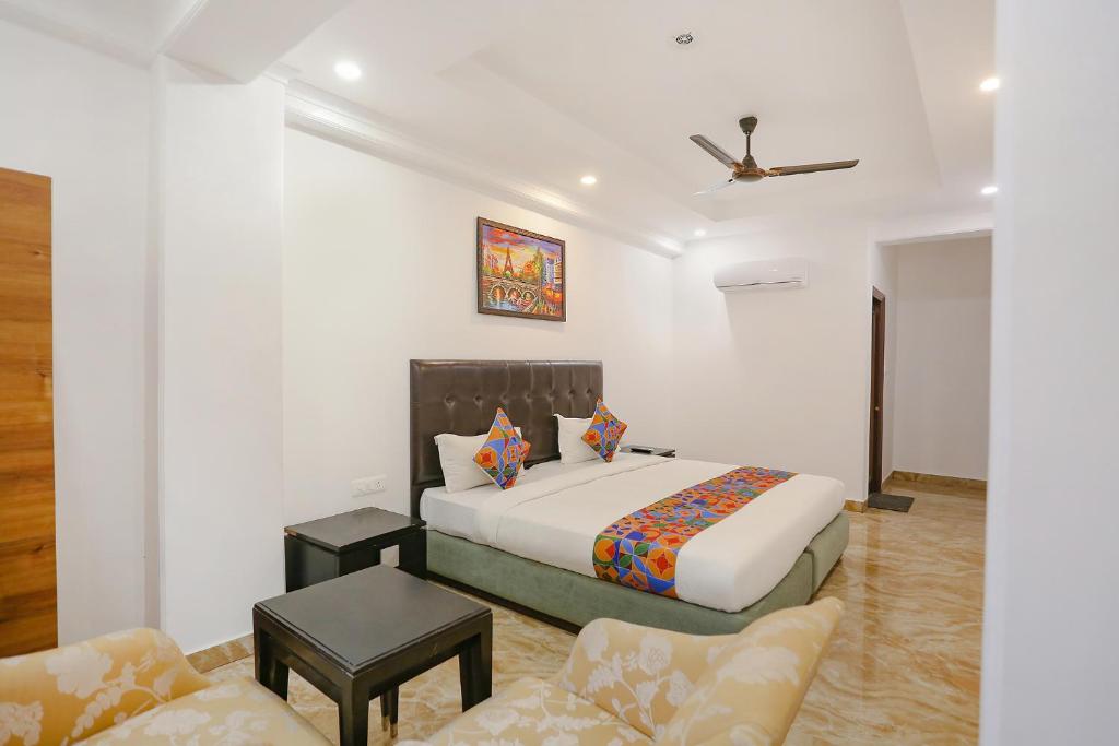 um quarto com uma cama king-size e um sofá em FabExpress Taj Residency em Nova Deli