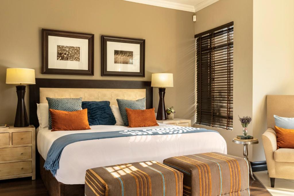 a bedroom with a large bed with orange and blue pillows at Sofala Lodge in Mokopane