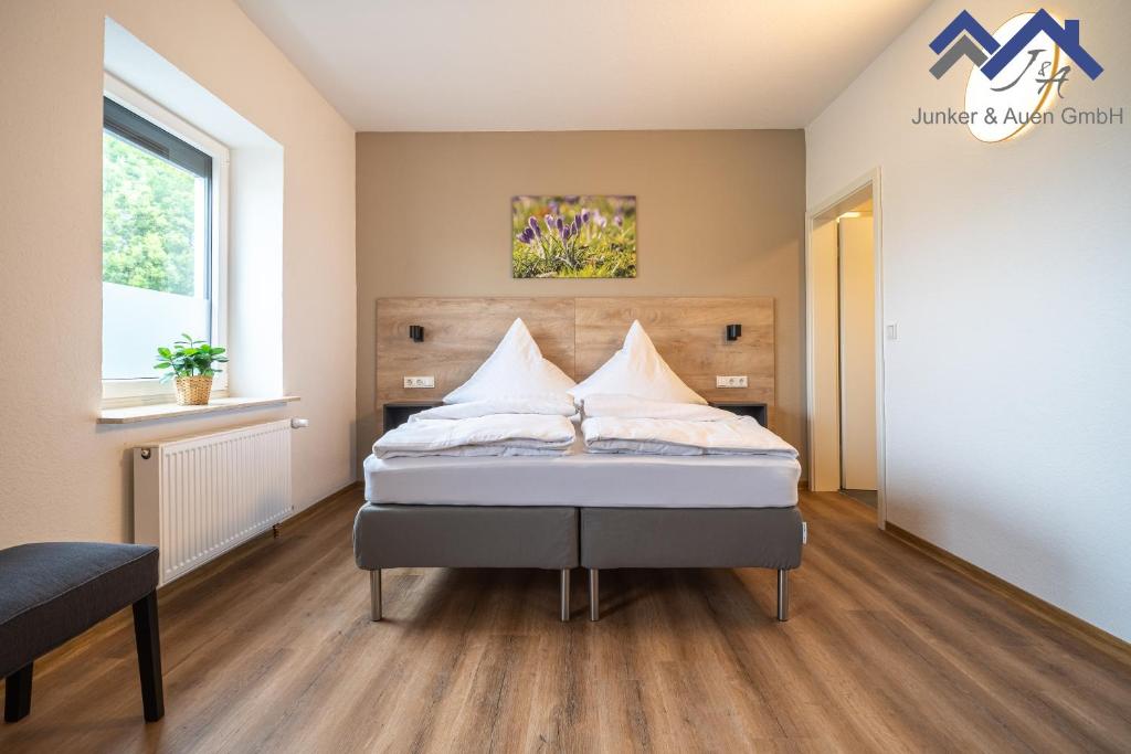 Un dormitorio con una cama con almohadas blancas. en Ferienapartments Junker & Auen, en Weener