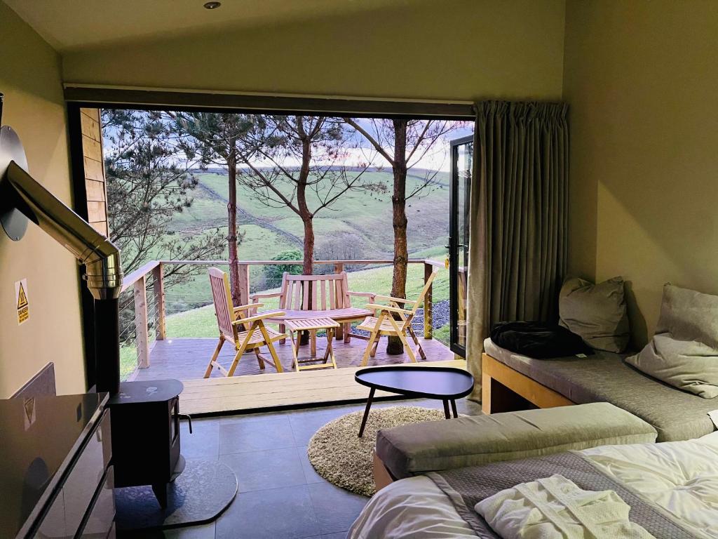 1 dormitorio con balcón con mesa y sillas en Valley View Pendle, en Foulridge