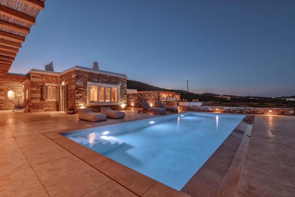 a swimming pool in front of a house at Levantes Villa Panagia beach in Antiparos