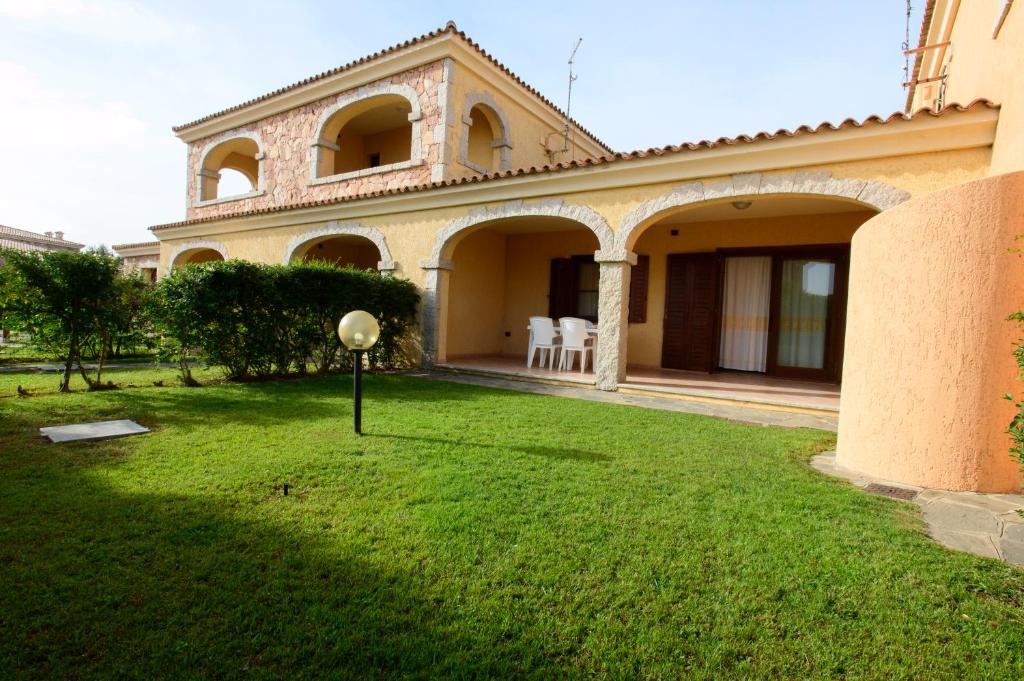 a large house with a yard with a grassy field at Ville del Mar in San Teodoro