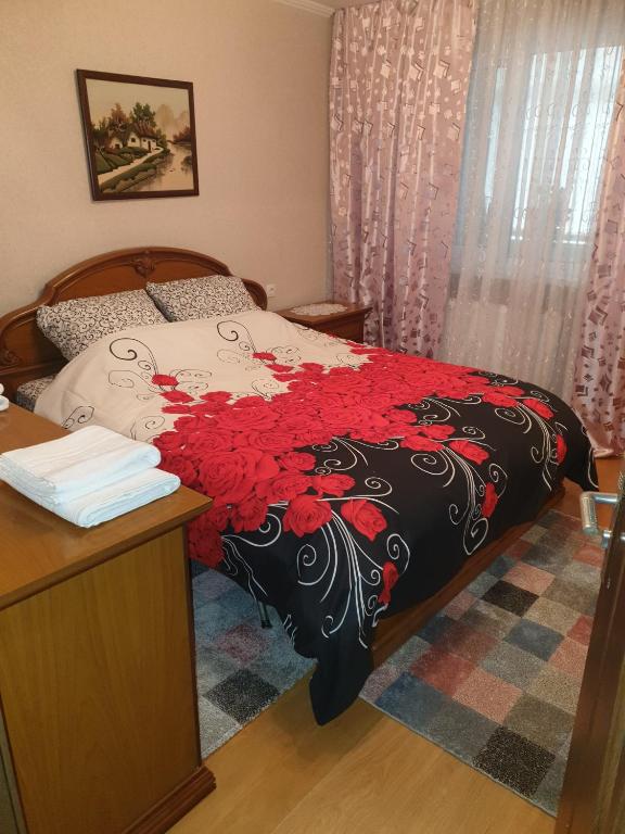 a bedroom with a bed with a black and red blanket at Alin Apartament in Iaşi