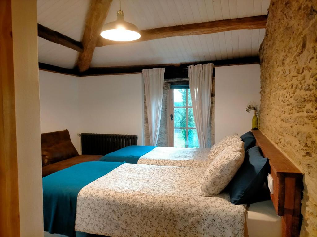 um quarto com 2 camas e uma janela em Granja Labrada: Alojamiento con caballos em Mañón